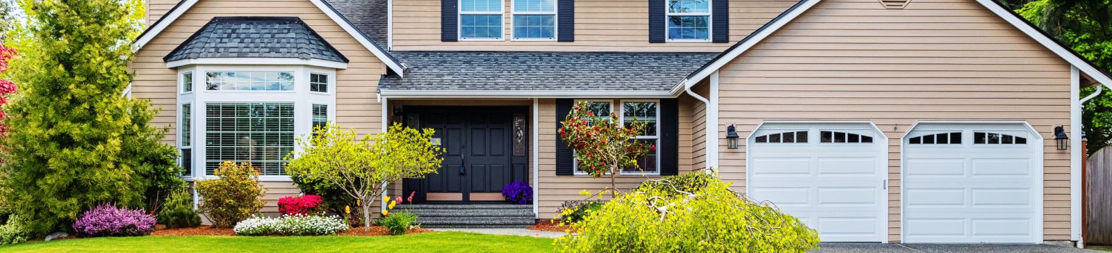 Modern suburban home in Belleville NJ with white garage doors, representing a comprehensive garage door FAQ resource